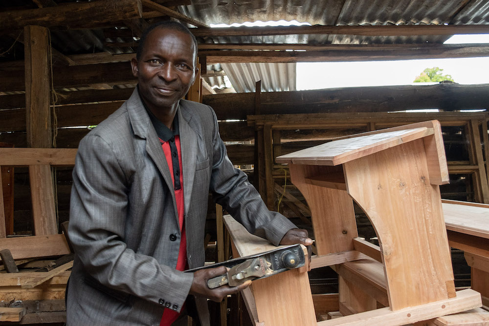 Villager Creating Desks for the School